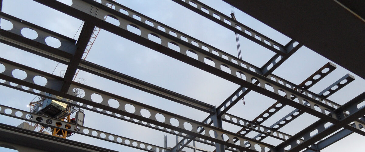 overhead view of sky through steel structure and beams