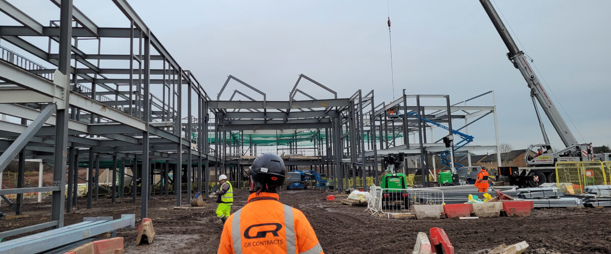 onstruction site with scaffolding partly complete and workforce