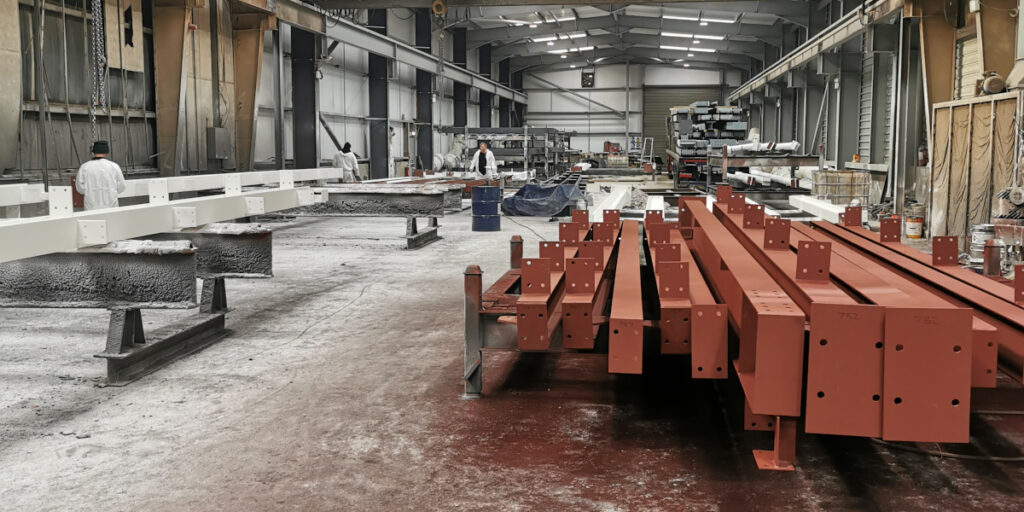 stacked steel girders in workshop